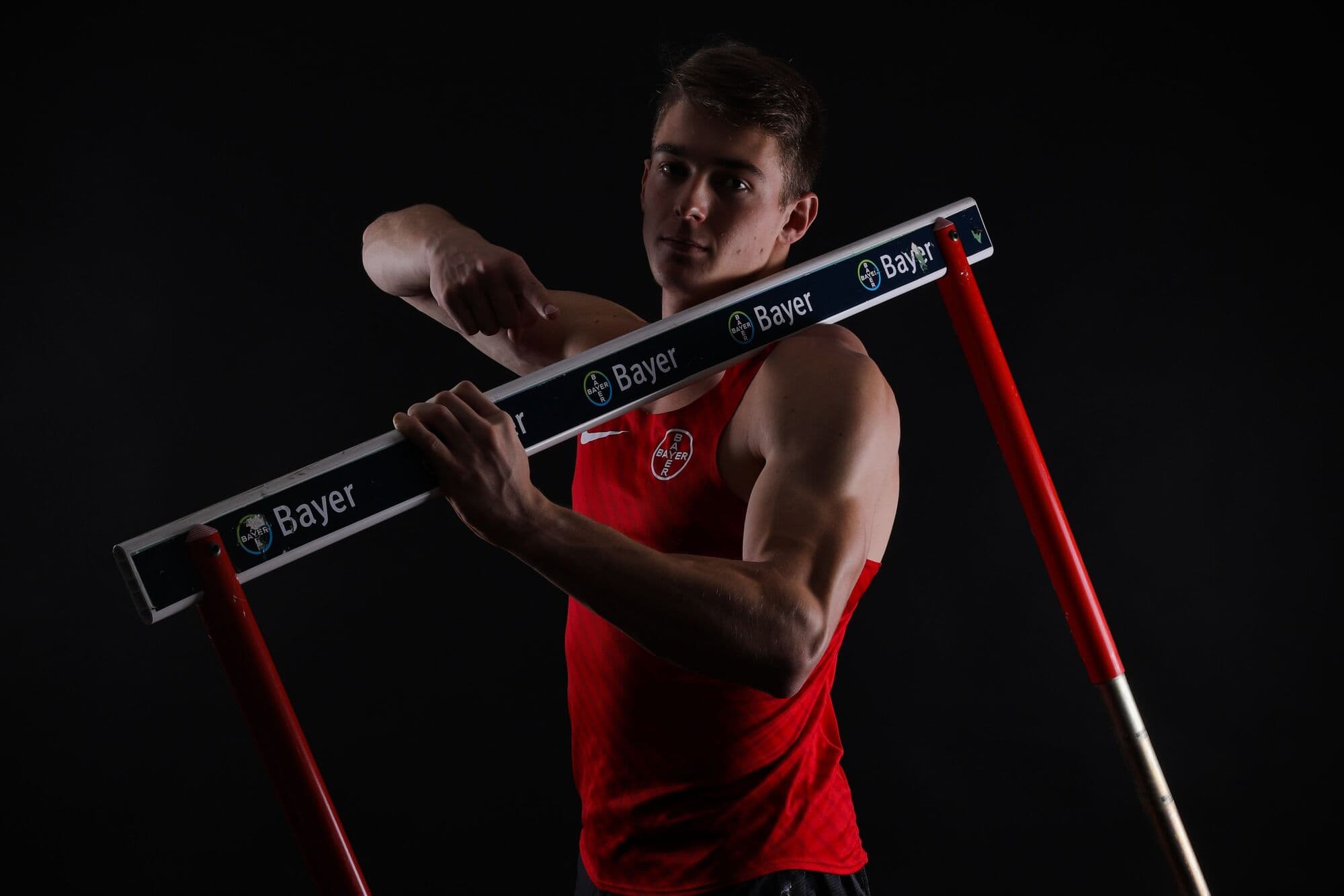 Tim Eikermann holding a hurdle crossbar